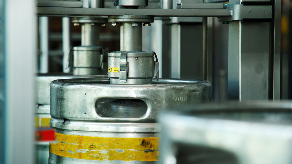 Mehrere Metallfässer werden in einer industriellen Maschine bearbeitet.