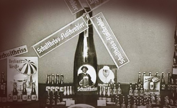 Eine Auswahl an Bierflaschen und Gläsern ist auf einem Werbestand arrangiert.