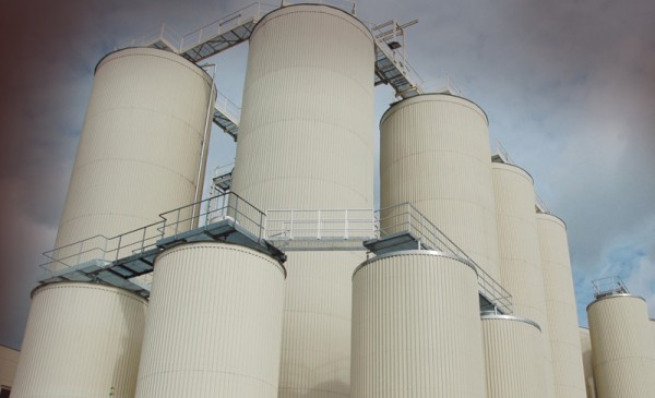Fünf hohe, schlanke Silos stehen unter einem bewölkten Himmel.