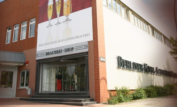 Ein Ladengeschäft mit großem Schild ist in einem modernen Gebäude untergebracht.