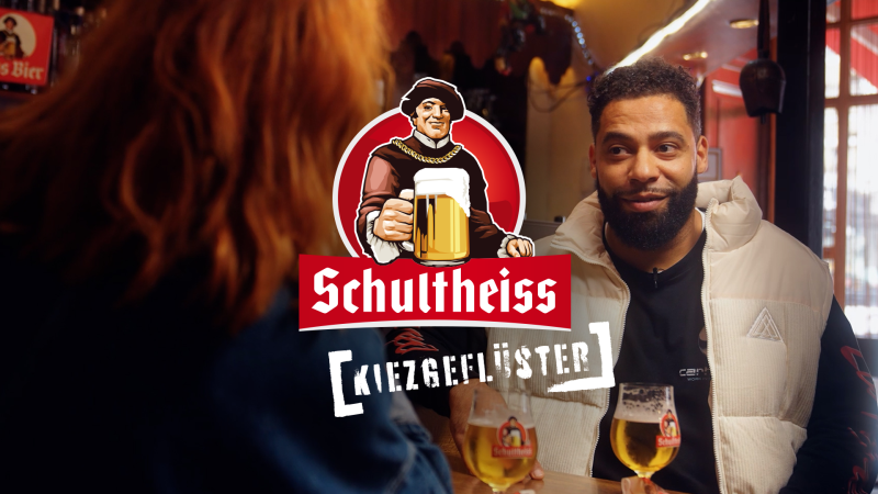Interviewsituationen zweier Personen in einer Kneipe, im Vordergrund ein grafisches Logo mit dem Text Schultheiss Kiezgeflüster.
