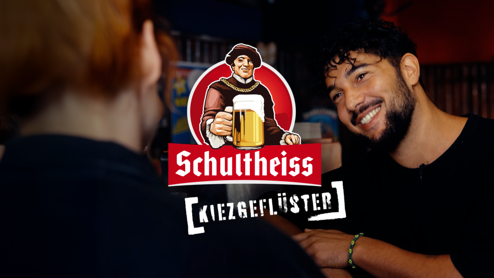 Interviewsituationen zweier Personen in einer Kneipe, im Vordergrund ein grafisches Logo mit dem Text Schultheiss Kiezgeflüster.