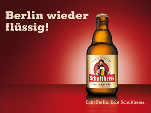 Eine Flasche Bier steht vor einem roten Hintergrund mit Text.