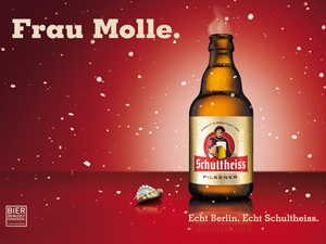 Eine Bierflasche steht neben einer Kronkorken auf rotem Hintergrund mit weißen Punkten.