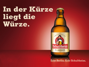 Eine Bierflasche steht vor einem roten Hintergrund mit einem deutschen Textslogan.